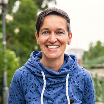 Barbara Andrä muss über den Fotografen lachen. Im Hintergrund der Wienfluss.